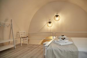 a room with a bed and a chair and lights at Dimora Daliah&Oana in Matera