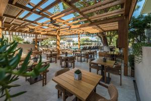 een buitenrestaurant met houten tafels en stoelen bij Contessa Hotel in Argassi