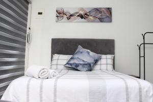 a bedroom with a bed with white and blue pillows at Tash's Place in Roodepoort