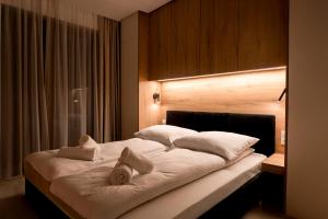 a bedroom with a large bed with white pillows at Apartament Zakrzówek - Chilloway in Krakow