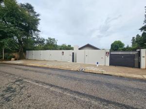 an empty street with a building with a garage at Tash's Place in Roodepoort
