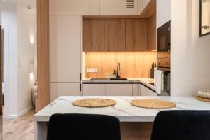 a kitchen with a table with two pizzas on it at Apartament Zakrzówek - Chilloway in Krakow