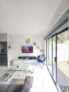 a living room with a couch and a tv at Tash's Place in Roodepoort