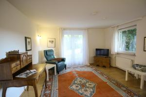 a living room with a table and a chair and a desk at HäuslmaierS Urlaubswohnung in Siegsdorf