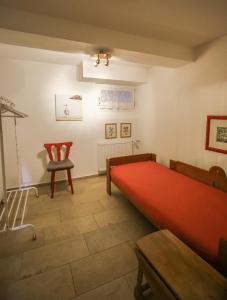 a room with a red bed and a chair at HäuslmaierS Urlaubswohnung in Siegsdorf