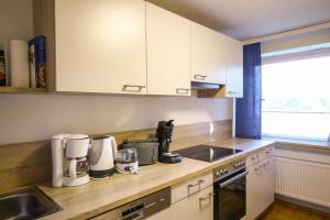 a kitchen with white cabinets and a counter top at HäuslmaierS Urlaubswohnung in Siegsdorf +13 photos