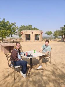 un uomo e una donna seduti a un tavolo di Little Haven Haveli - Homestay - Family Friendly a Bikaner