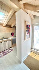 a kitchen with white walls and wooden ceilings at Casa Lilla in Gravedona