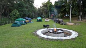 a group of tents in a field with a fire pit at ViangPhing Resort in Mae Chan