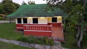 a red and white house with a green roof at ViangPhing Resort in Mae Chan