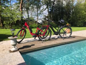 two bikes are parked next to a swimming pool at Villa Sparadis in Spa