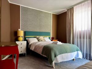 a bedroom with a bed and a large window at Casa Fraga in Beiuş