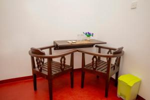 a wooden table with two chairs and a table with at Breeze Heavens Yala in Polgahawelana