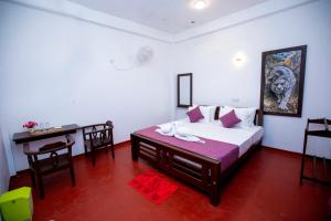 a bedroom with a bed and a table and a desk at Breeze Heavens Yala in Polgahawelana