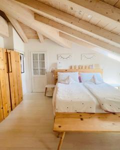 a bedroom with a wooden bed in a room with wooden ceilings at Casa Lilla in Gravedona