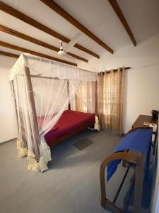 a bedroom with a bed with a mosquito net at Surf Forever in Midigama East