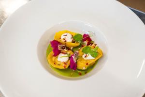 a white bowl filled with food on a white plate at Hotel Continental in Andalo