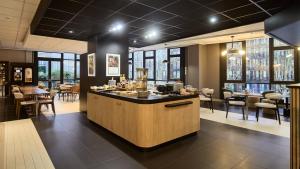 a bar in a restaurant with chairs and tables at Campanile PRIME - Arcueil in Arcueil
