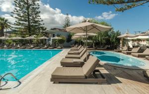 a pool with lounge chairs and umbrellas at Contessa Hotel in Argassi