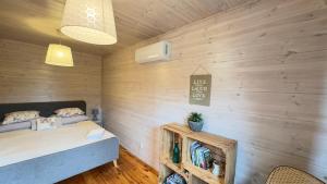 a bedroom with a bed and a wooden wall at Siedlisko Wytowno in Ustka