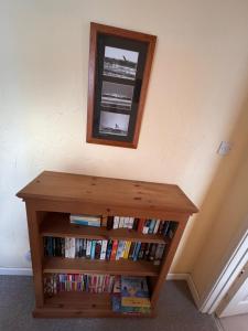 a book shelf with books and a mirror on the wall at Mordor Lodge in Braunton