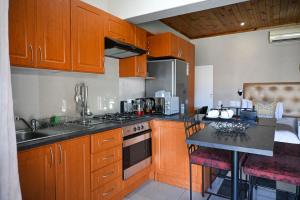 a kitchen with wooden cabinets and a counter top at Matts Rest Bnb & Self-catering in Pietermaritzburg