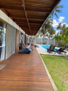 a porch with a hammock on the side of a house at Coco Ville SMG in São Miguel do Gostoso