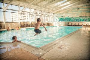 a man and a boy in a swimming pool at The Oceanfront Inn - Virginia Beach in Virginia Beach