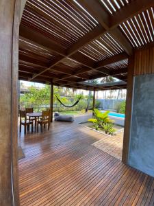 a patio with a table and chairs and a wooden ceiling at Coco Ville SMG in São Miguel do Gostoso