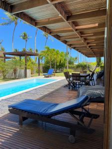 a wooden deck with a pool and a table and chairs at Coco Ville SMG in São Miguel do Gostoso