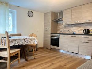 a kitchen with a table with chairs and a clock on the wall at Casa Valentina Livigno in Livigno