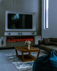 a living room with a tv above a fireplace at Ubuntu Residence in Ruhengeri