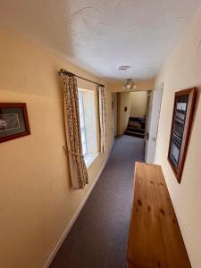 a room with a hallway with a table and a window at Mordor Lodge in Braunton