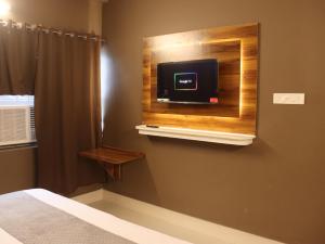 ein Schlafzimmer mit einem Bett und einem Fernseher an der Wand in der Unterkunft Roomssolution ! Best Hotel In Patna in Gulzārbāgh