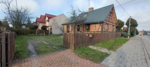 a house with a wooden fence in a yard at Plażowa Przytulny Dom Na Wyłączność in Białystok