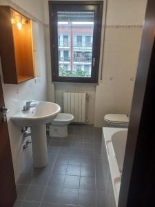 een badkamer met een wastafel en een toilet en een raam bij Residenza Caniana in Torre Boldone