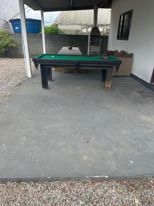 un tavolo da ping pong verde davanti a una casa di Bela casa de praia a Palhoça