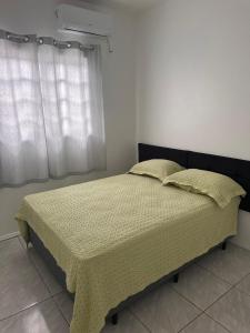 una camera da letto con un letto e una finestra di Bela casa de praia a Palhoça Altre 11 foto