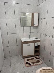 un bagno con lavandino e specchio di Bela casa de praia a Palhoça