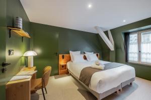 een slaapkamer met groene muren, een bed en een bureau bij Maison Soyeuse in Briançon +66 foto's
