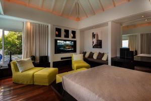 una camera da letto con un letto, un divano e una TV di Tropical paradise 