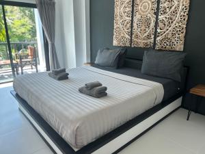 a bedroom with a bed with towels on it at Aqua Suites in Wok Tum