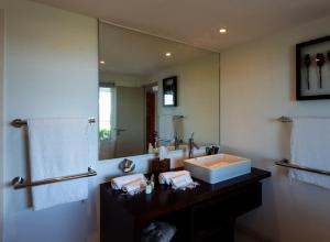 un bagno con un lavandino e un grande specchio di Tropical paradise  Altre 4 foto