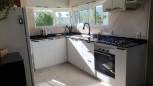 a kitchen with white cabinets and a stove top oven at Casa en Punta Colorada con gran fondo y fogón in Punta Colorada