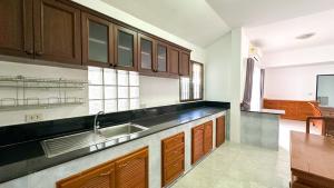 a kitchen with wooden cabinets and a sink at Soulful Stay Phuket -Distant Seaview and Mountain View Retreat, Patong in Patong Beach +135 photos