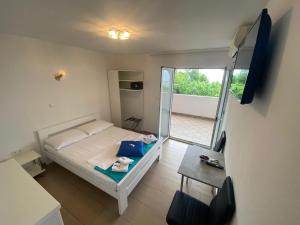 a small bedroom with a bed and a balcony at Apartments Matteo in Omišalj