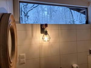 a bathroom with a window and a light on the wall at Woeste Hoogte - Groesbeek in Groesbeek +70 photos