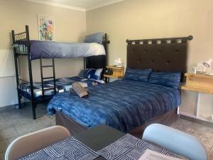 a bedroom with two bunk beds and a bed at Midway En Route in Harrismith