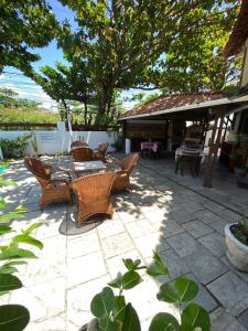a patio with wicker chairs and a table on a patio at Pousada Rota Beach in Porto De Galinhas