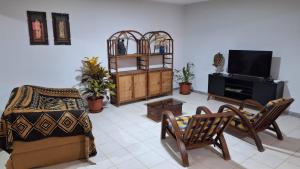 a living room with a couch and a tv at Kaza Manata in Praia